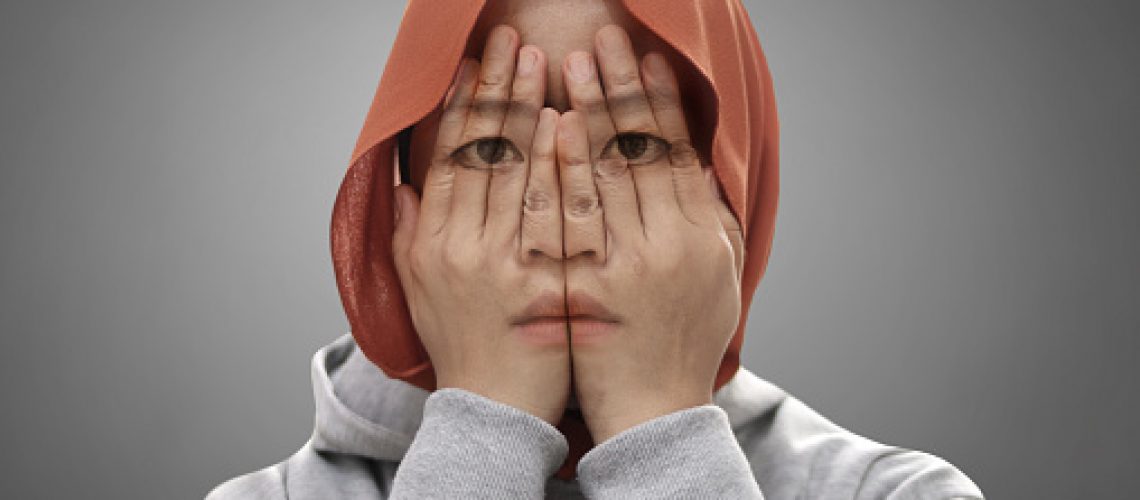 Mysterious Asian muslim covering her face with hands, multiple exposure shows her sad depressed facial expression